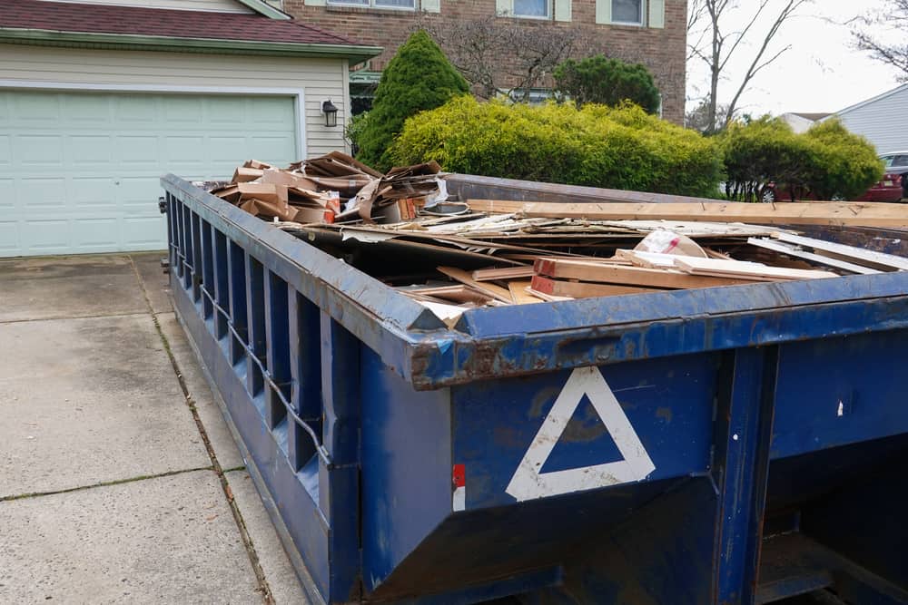 Long,Blue,Dumpster,Full,Of,Wood,And,Other,Debris,In